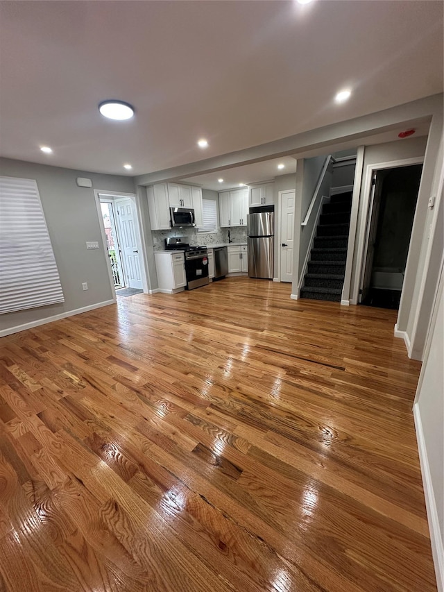 223-45 113th Dr, Queens Village, NY 11429 - unfurnished living room featuring stairs, light wood finished floors, and recessed lighting