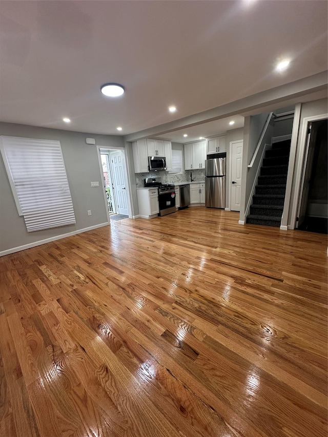 223-45 113th Dr, Queens Village, NY 11429 - unfurnished living room featuring stairway, light wood-style flooring, and recessed lighting