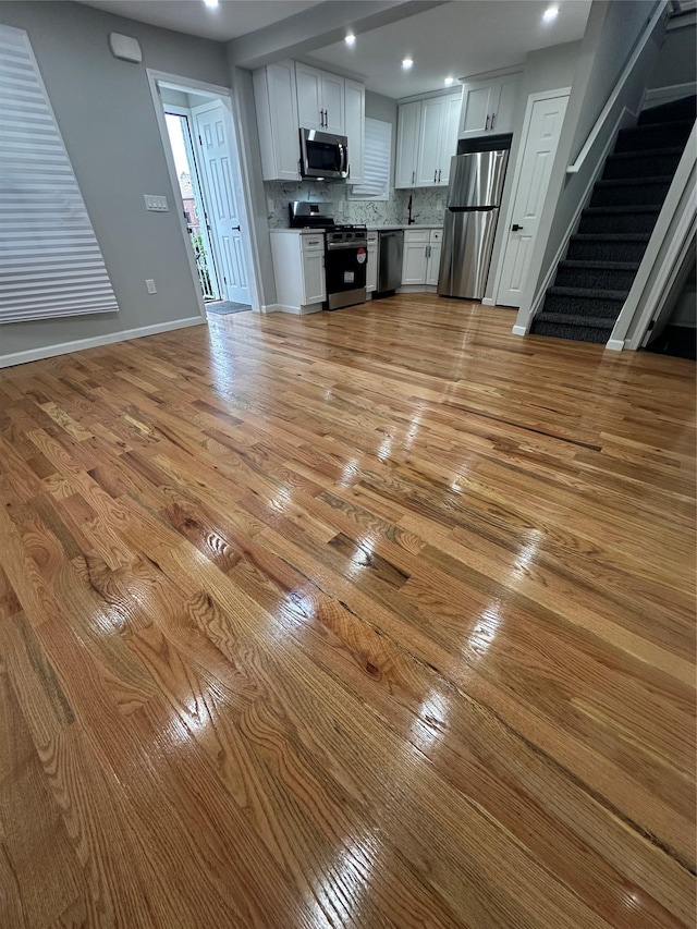 223-45 113th Dr, Queens Village, NY 11429 - unfurnished living room with light wood finished floors, stairway, and recessed lighting