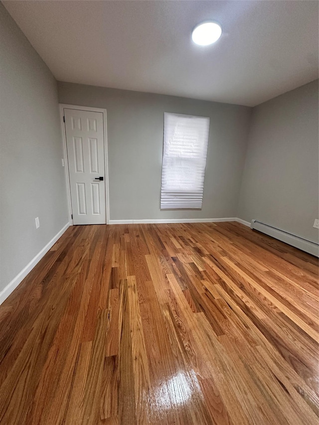 223-45 113th Dr, Queens Village, NY 11429 - empty room featuring wood finished floors and a baseboard radiator