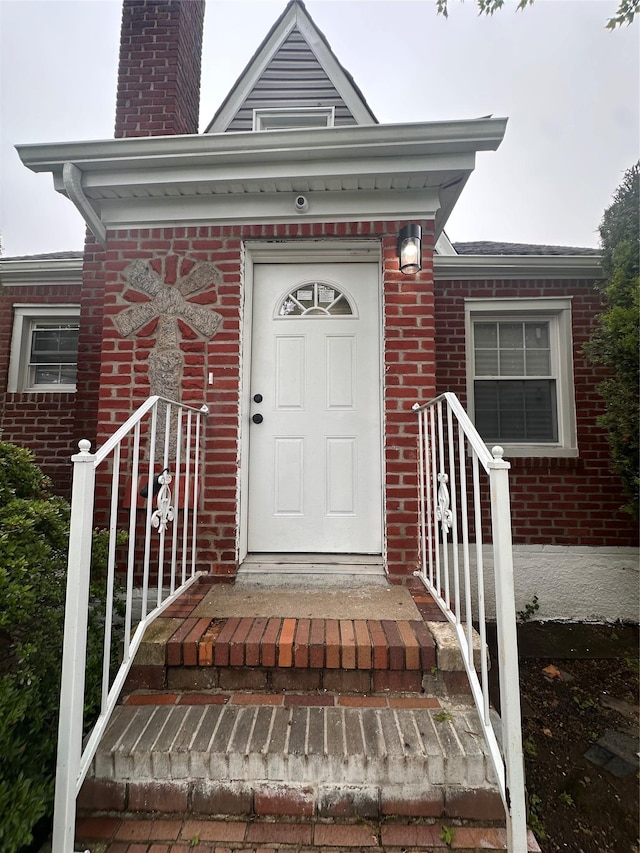 223-45 113th Dr, Queens Village, NY 11429 - doorway to property with brick siding and a chimney
