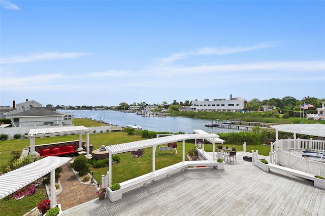 wooden deck featuring a water view, a lawn, and a pergola