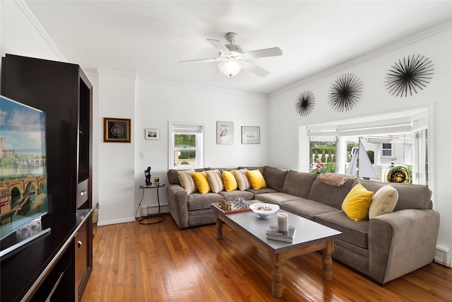 living area featuring a ceiling fan, a baseboard heating unit, wood finished floors, crown molding, and a baseboard radiator