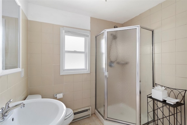 full bath featuring a baseboard radiator, a stall shower, tile patterned floors, tile walls, and a sink