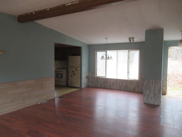 unfurnished room with vaulted ceiling with beams and wood finished floors