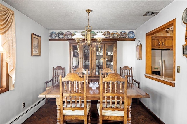 dining space featuring visible vents, a notable chandelier, a baseboard heating unit, a textured ceiling, and baseboards