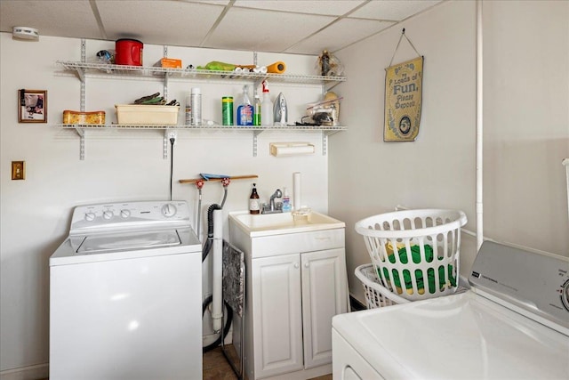 clothes washing area with cabinet space, separate washer and dryer, and a sink