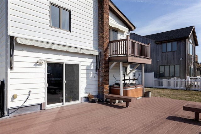 wooden deck with a hot tub and fence