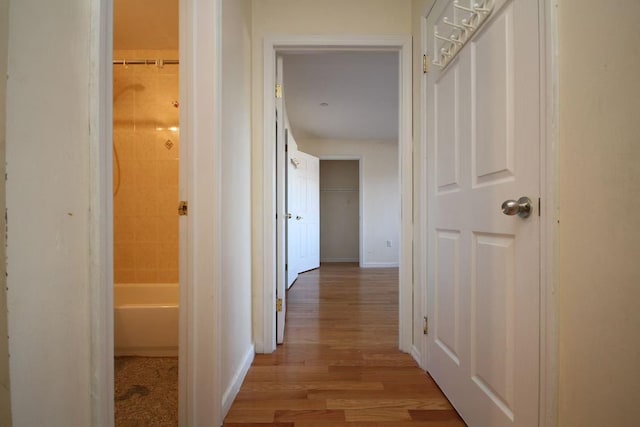 hall featuring baseboards and light wood finished floors