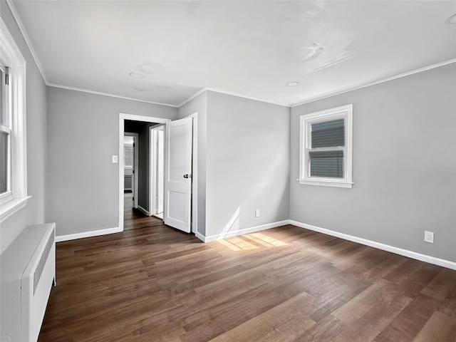 spare room with ornamental molding, radiator heating unit, baseboards, and wood finished floors