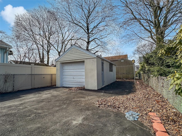 detached garage with driveway and fence