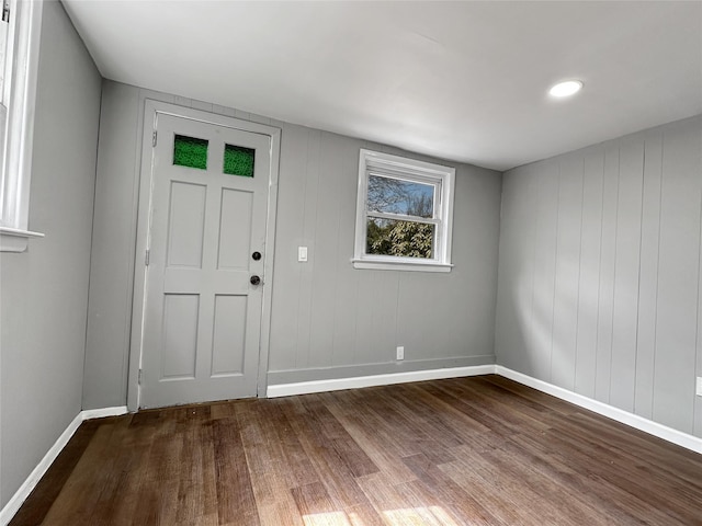 empty room with baseboards and dark wood-type flooring