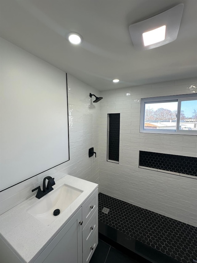 full bath with tile patterned floors, recessed lighting, tiled shower, and vanity