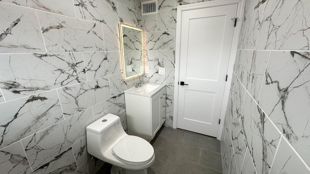 12 Meridian Rd, Levittown, NY 11756 - half bath with visible vents, toilet, vanity, stone wall, and tile walls