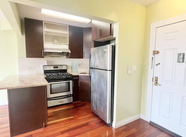 kitchen with tasteful backsplash, appliances with stainless steel finishes, baseboards, and dark wood-style flooring