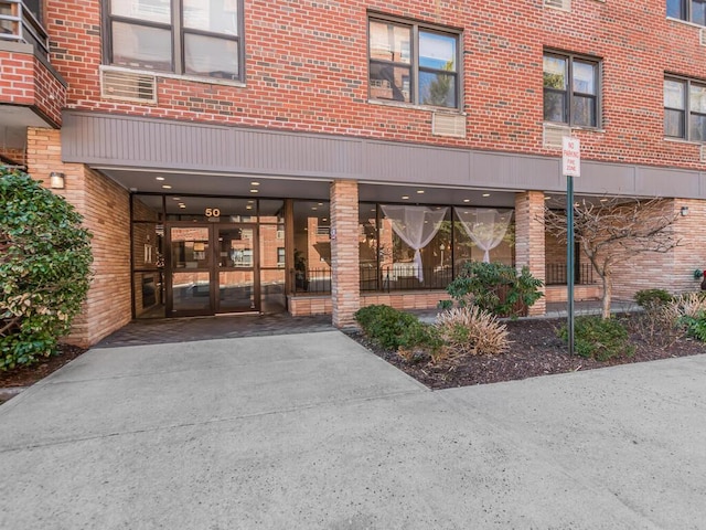 view of exterior entry featuring french doors and brick siding