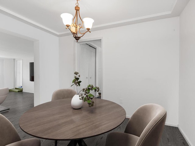 dining area featuring dark wood-style floors, baseboards, and a chandelier