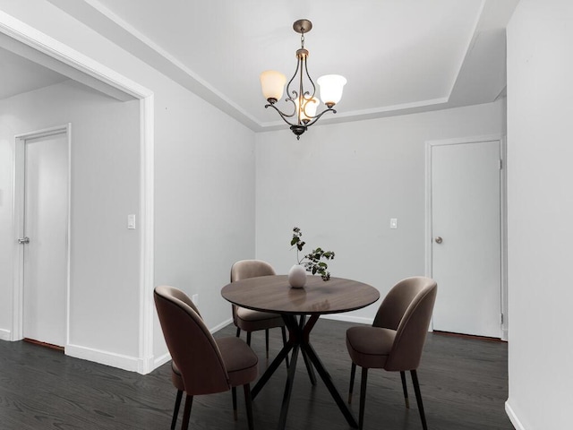 dining room featuring a tray ceiling, baseboards, an inviting chandelier, and dark wood-style floors