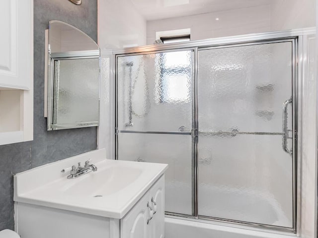 full bath with vanity and shower / bath combination with glass door