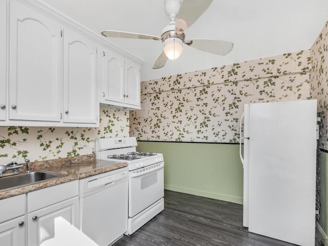 kitchen featuring a sink, wallpapered walls, white appliances, white cabinetry, and dark wood-style flooring