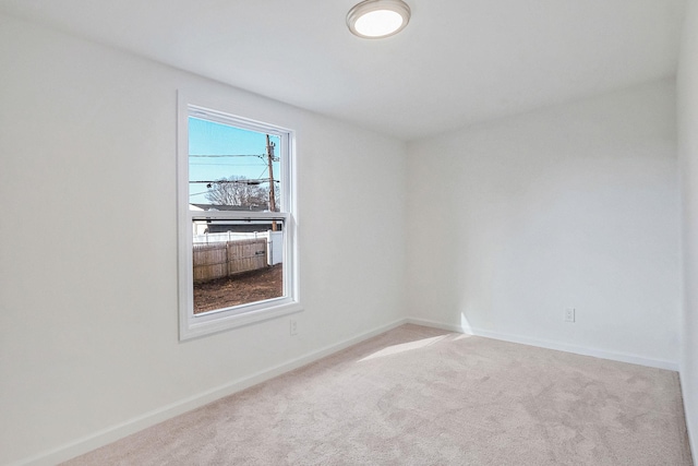 carpeted spare room featuring baseboards