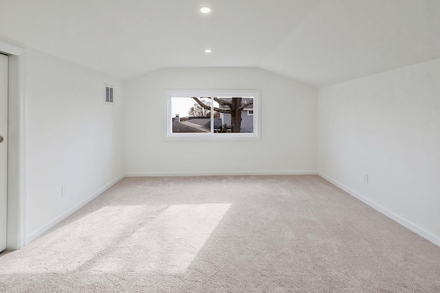 empty room with visible vents, light carpet, lofted ceiling, recessed lighting, and baseboards