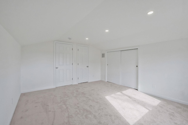 unfurnished bedroom with visible vents, lofted ceiling, recessed lighting, carpet floors, and baseboards