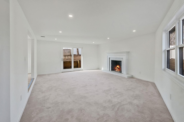 unfurnished living room featuring recessed lighting, baseboards, carpet floors, and a brick fireplace