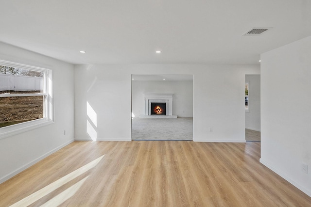 unfurnished living room featuring visible vents, recessed lighting, baseboards, and light wood-style floors