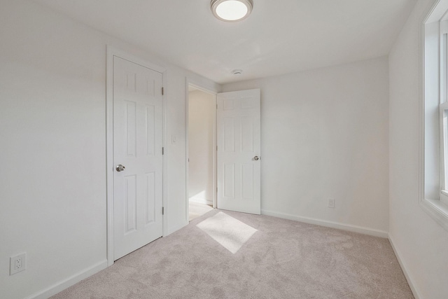 unfurnished bedroom featuring carpet and baseboards