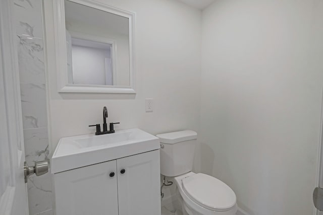 bathroom featuring baseboards, toilet, and vanity