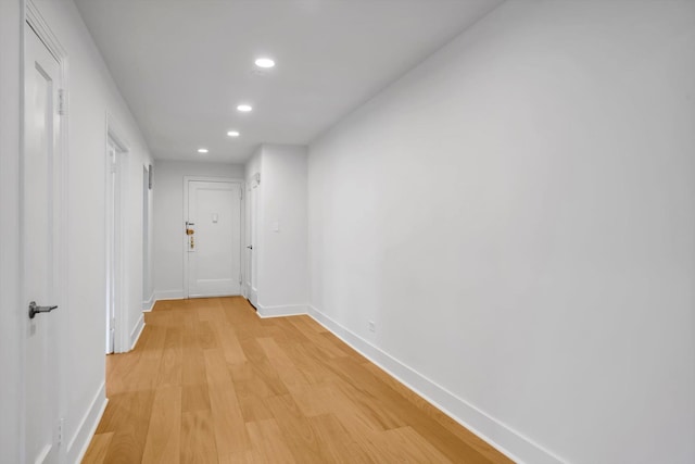 hall with recessed lighting, light wood-type flooring, and baseboards