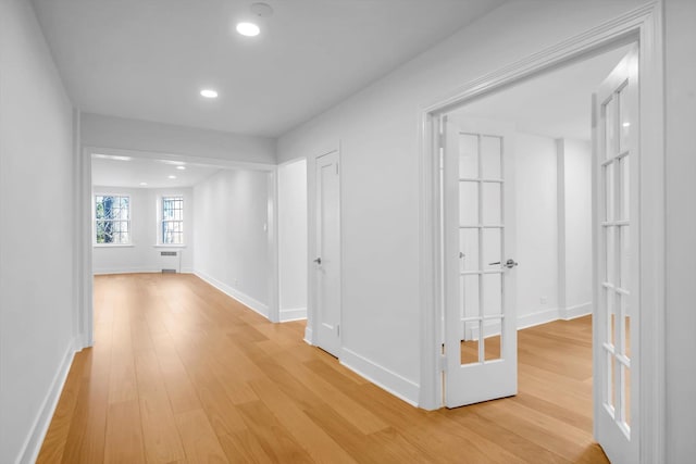 hall featuring recessed lighting, baseboards, and light wood-style flooring