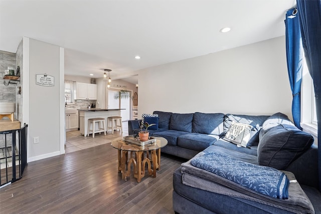 living room featuring recessed lighting, baseboards, and wood finished floors