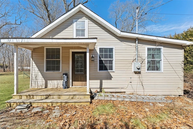 bungalow-style home with a front lawn and covered porch