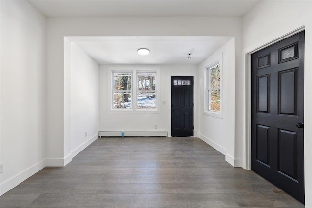 foyer with a wealth of natural light, a baseboard heating unit, and wood finished floors