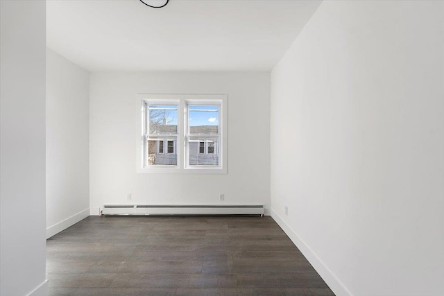 unfurnished room featuring a baseboard heating unit, wood finished floors, and baseboards