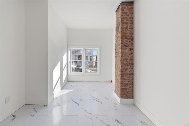 hallway featuring baseboards and marble finish floor