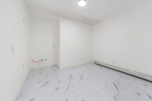 unfurnished room with baseboards, marble finish floor, and baseboard heating