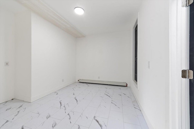 empty room featuring baseboards, marble finish floor, and a baseboard radiator