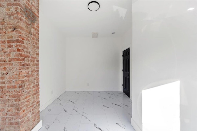 empty room with marble finish floor and baseboards