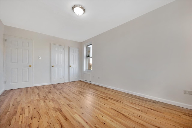 unfurnished bedroom with light wood finished floors, a closet, and baseboards