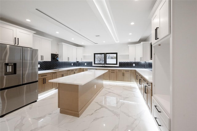 kitchen with marble finish floor, stainless steel refrigerator with ice dispenser, open shelves, a center island, and recessed lighting