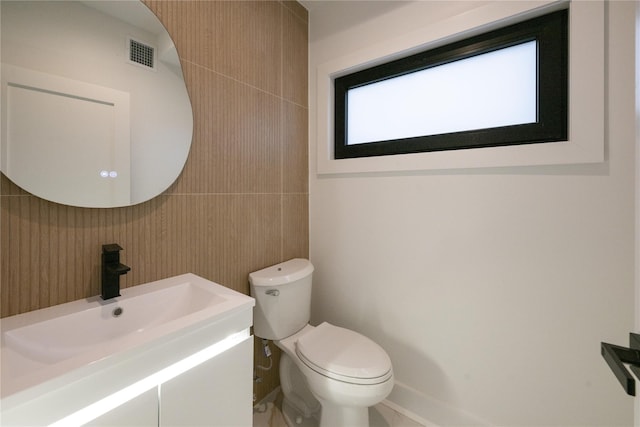 bathroom featuring visible vents, toilet, and vanity