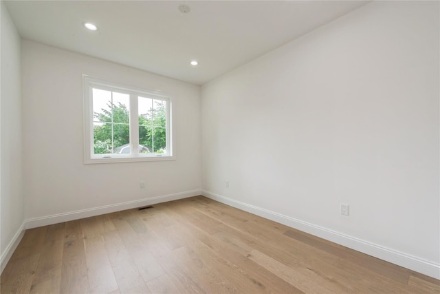 spare room featuring light wood-style flooring, recessed lighting, baseboards, and visible vents