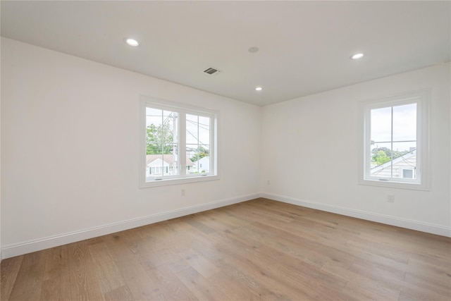 spare room with recessed lighting, light wood-style flooring, visible vents, and baseboards