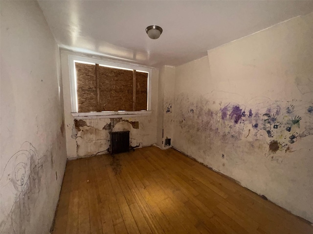 unfurnished room featuring radiator and wood-type flooring