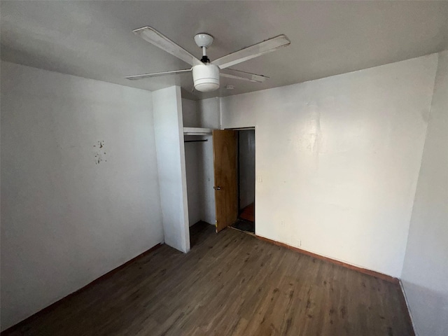 unfurnished bedroom featuring a closet, wood finished floors, and a ceiling fan