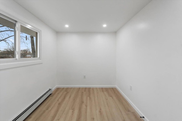 spare room featuring recessed lighting, a baseboard radiator, baseboards, and light wood finished floors