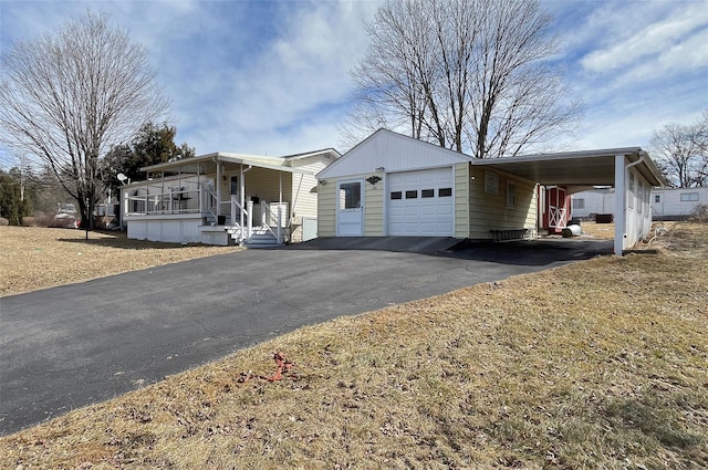 view of front of home featuring a carport, a garage, covered porch, and driveway